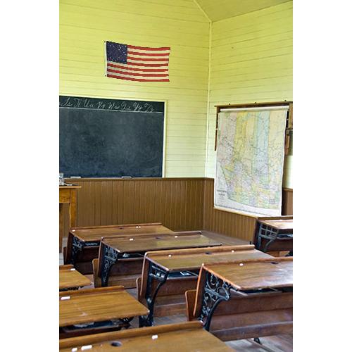 Nylon American Flag - Beacon® hanging on the wall of a vintage classroom with wooden desks and a chalkboard.