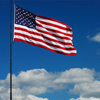 Nylon American Flag - Beacon® flying against a blue sky with white clouds, showing vibrant red, white, and blue colors.