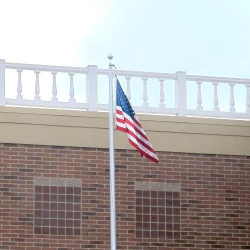 flag on pole against brick wall