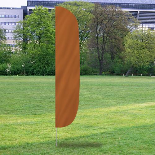 Solid Color Flutter Flags in a solid rust orange color standing upright on a grass field with trees and buildings in the background.