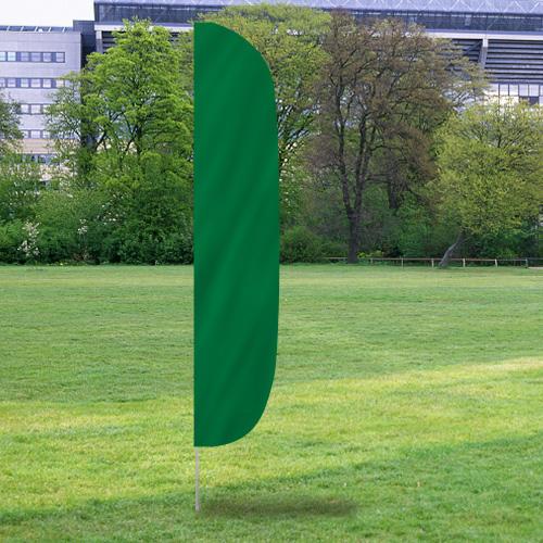 Solid Color Flutter Flags in green set up outdoors on a grassy field with trees and buildings in the background.