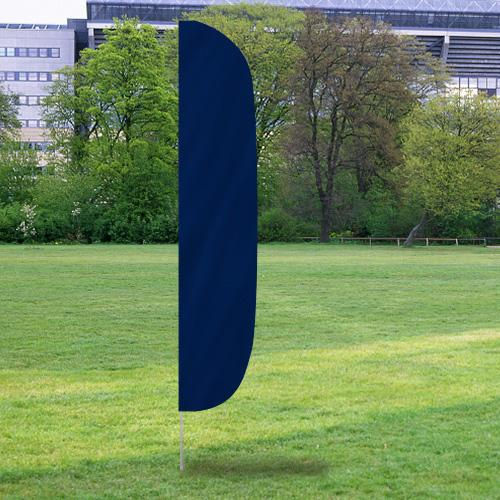 Solid Color Flutter Flags in dark blue standing upright on a grassy field with trees and buildings in the background.