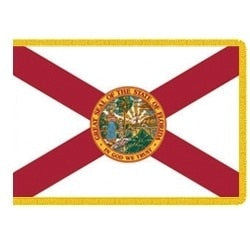 Indoor Florida state flag with red cross, state seal, and gold fringe