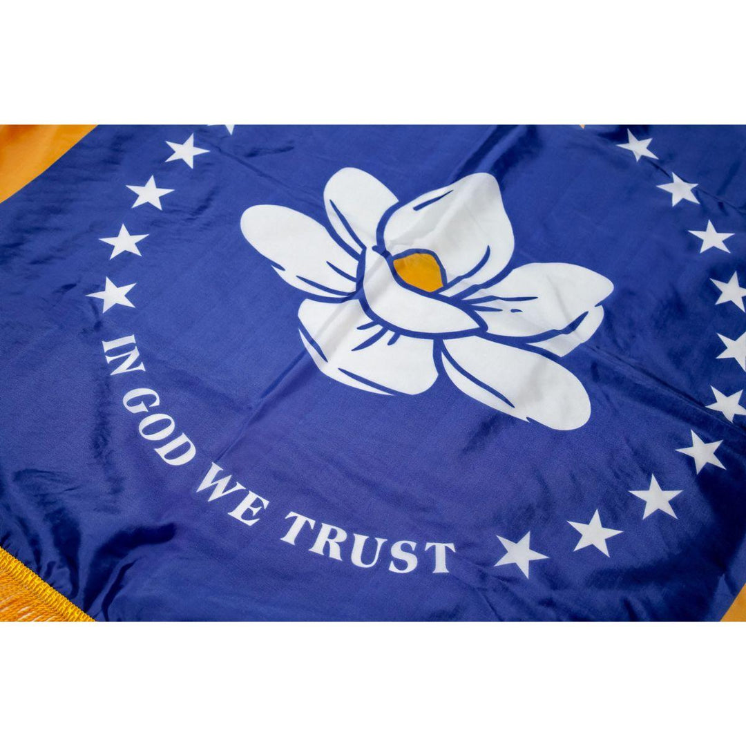 Close-up of Mississippi state flag magnolia emblem with stars and ‘In God We Trust’ text