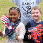 Kids smiling while waving US flags