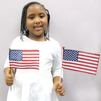Kid holding two mini U.S. Flags