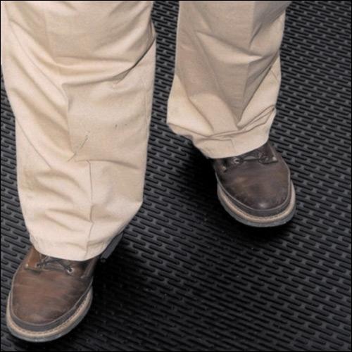 feet in brown shoes on black mat